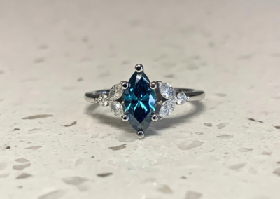 Luxury yellow gold three-stone ring with blue sapphire centre, handcrafted in Leduc, AB
